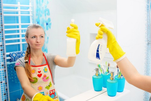 Professional home cleaner dusting a living room